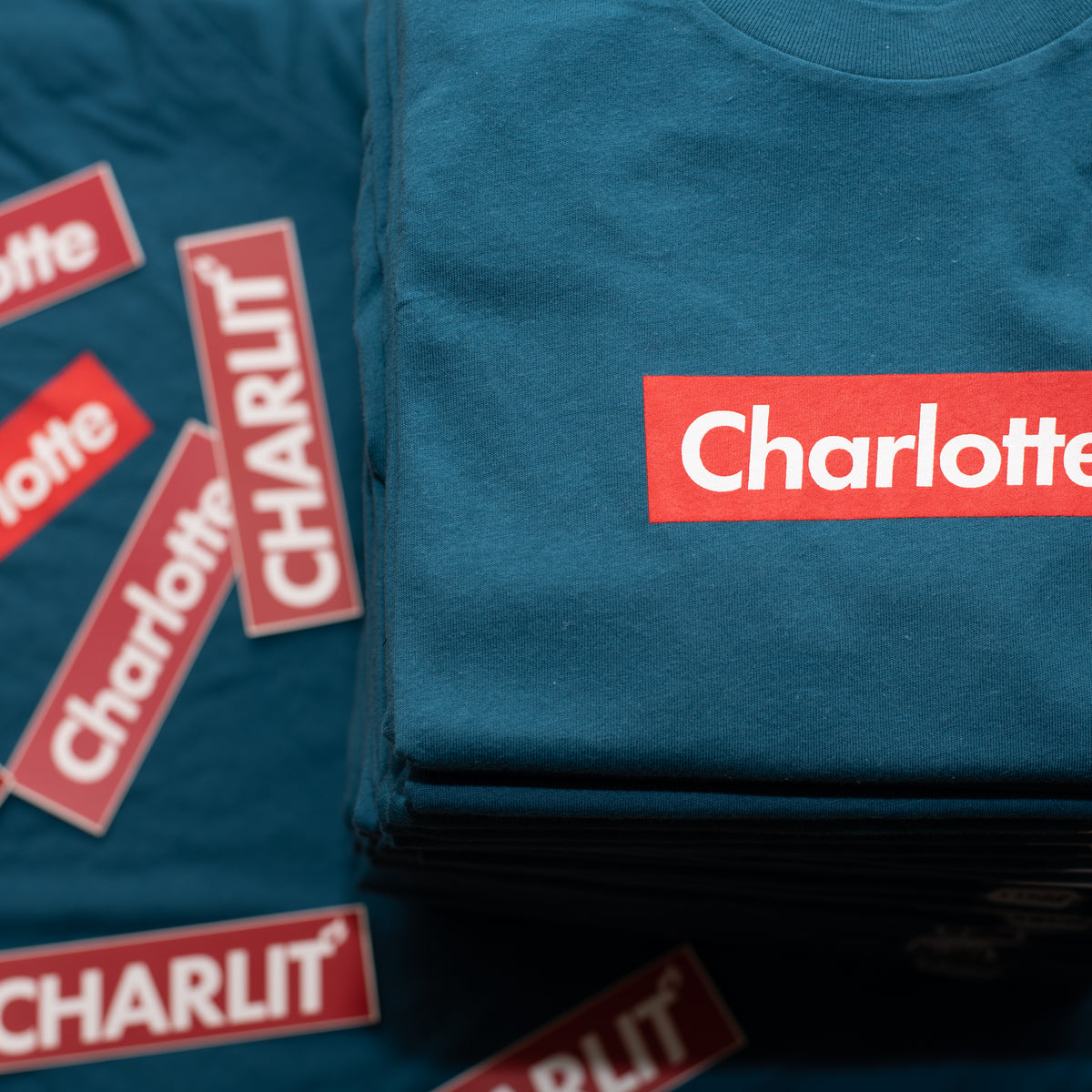 A stack of Box Charlotte Tees from CHARLIT Apparel
